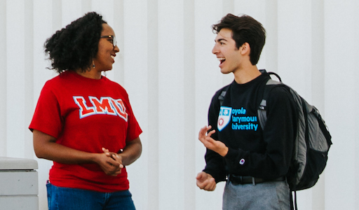 Students in LMU gear talking to each other outside