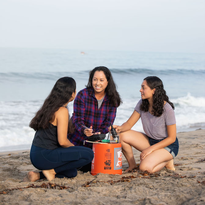 Professor Vazquez with students on the beach.