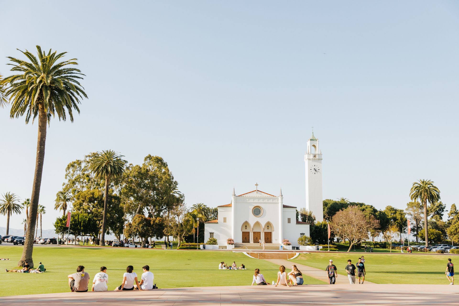 Church overlooking lawn with students sitting and walking